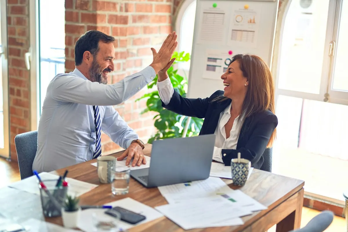 Consultora imobiliária comemorando com cliente durante atendimento