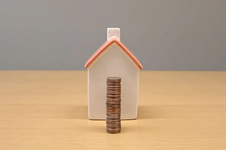 Miniatura de casa com pilha de moedas