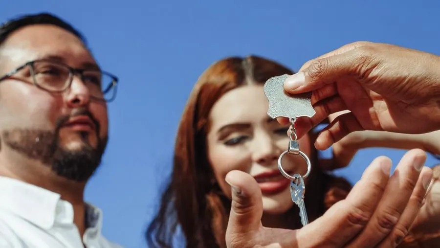 Casal recebendo a chave do primeiro imóvel